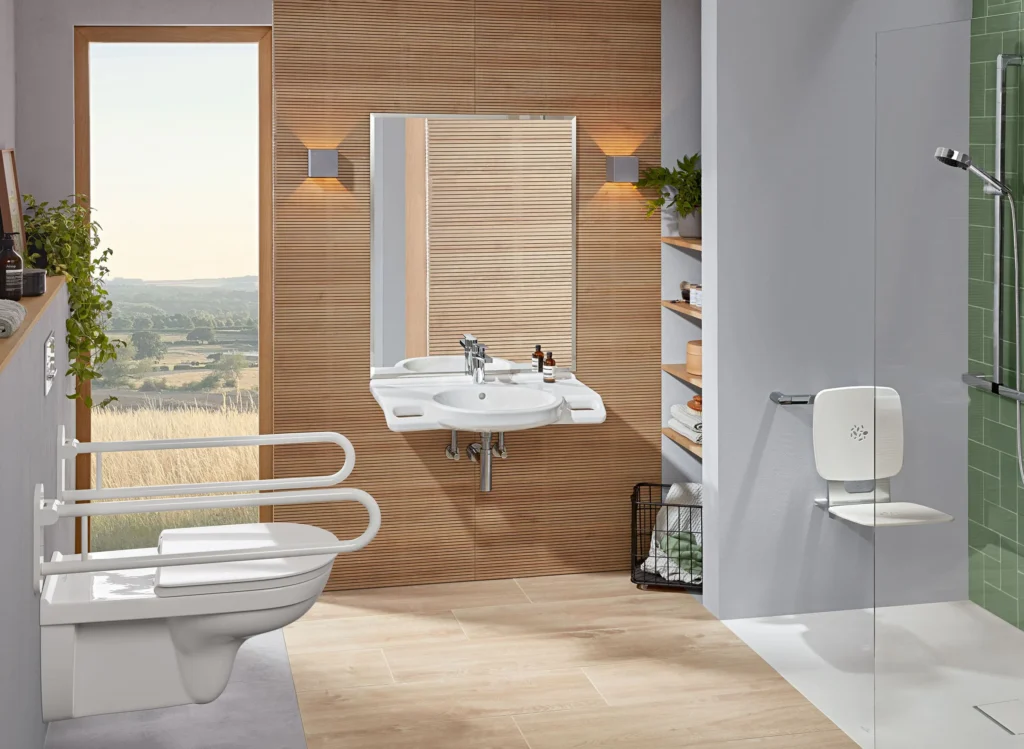 Barrierefreies Badezimmer mit Haltegriffen am WC, unterfahrbarem Waschbecken und bodengleicher Dusche mit Klappsitz