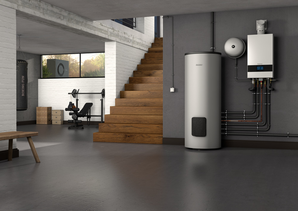 Moderner Technikraum mit großem Warmwasserspeicher und Heizgerät an der Wand, Holztreppe im Hintergrund und Fitnessgerät neben Fenster
